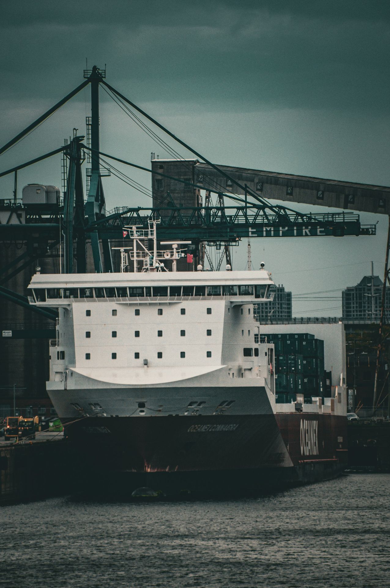a cruise ship docked at a dock with a crane in the background